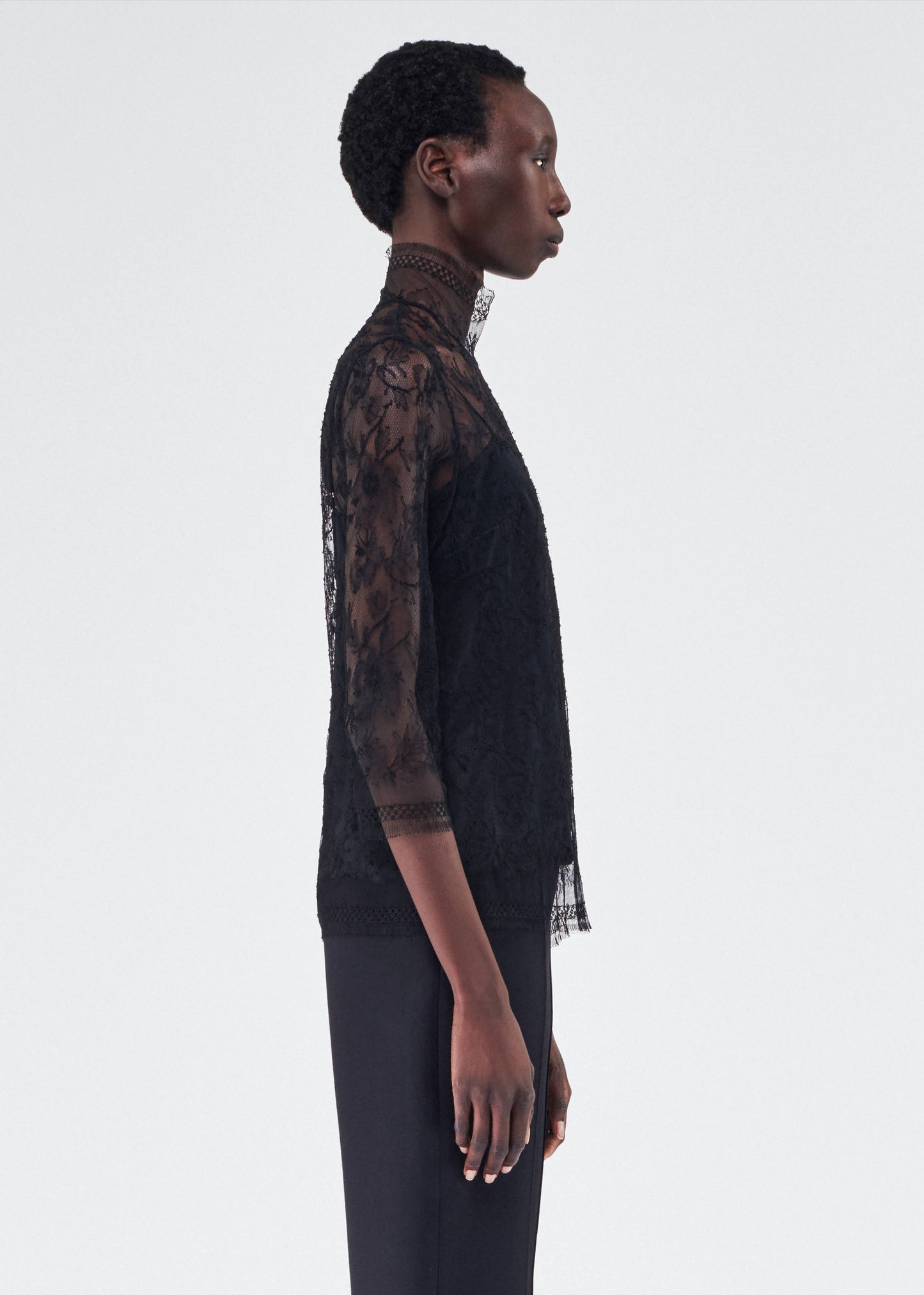 side view model wearing the adam lippes chantilly lace turtleneck in black