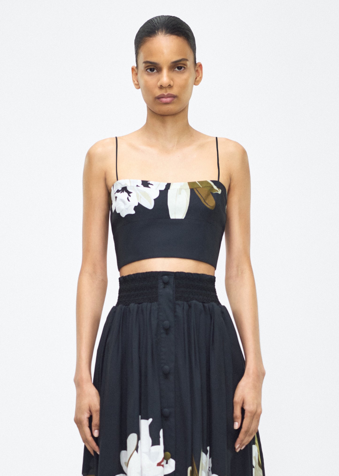 Model facing front – bex top, P25143PV, black/white – Adam Lippes, P25 collection: Crafted from 100% cotton voile, the Bex Top showcases this season’s Sicily-inspired floral motif. The cropped silhouette offers a modern fit, while delicate straps and a clean neckline lend a minimalist touch.