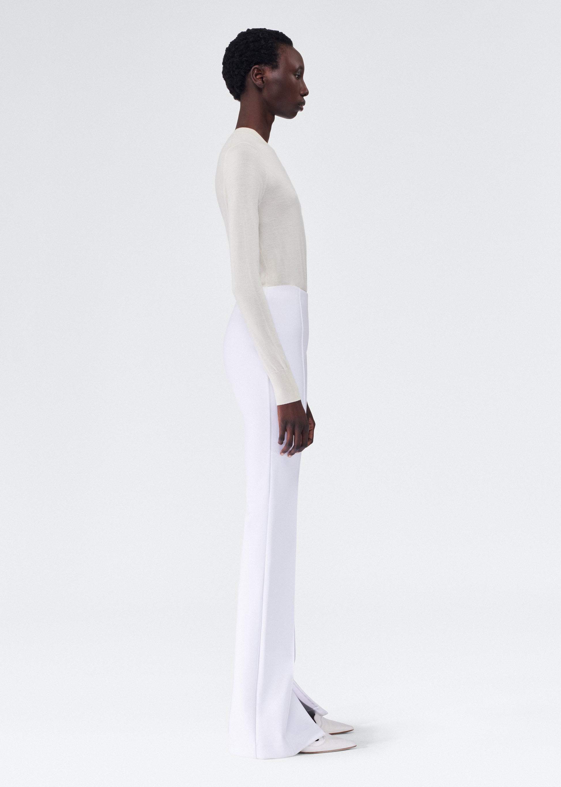 side view of model wearing the adam lippes eva flare pant in bonded neoprene in white
