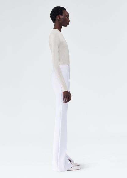 side view of model wearing the adam lippes eva flare pant in bonded neoprene in white