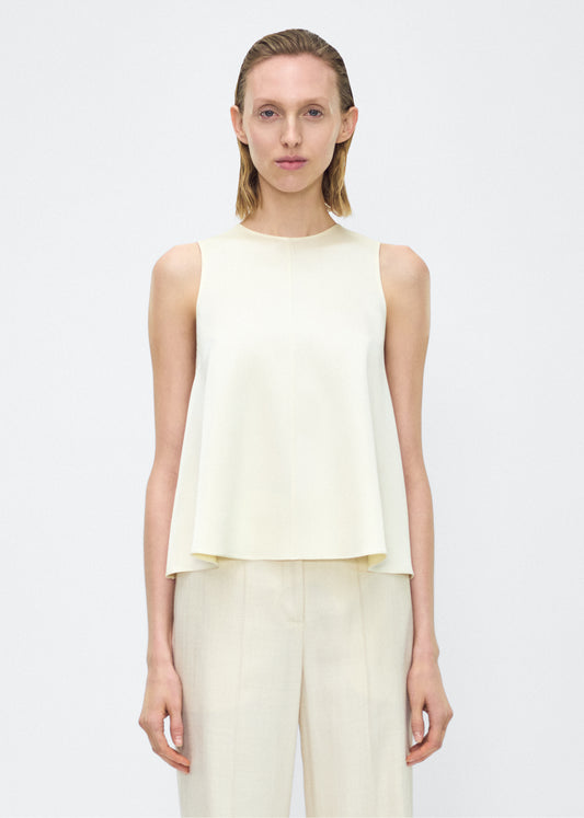 Image of model facing front– Elias Top, P25109HM, Cream – Adam Lippes, P25 collection: Crafted from luxurious double-face silk charmeuse, the Elias Top flows with effortless ease in a sleeveless silhouette that falls gracefully from the shoulders.