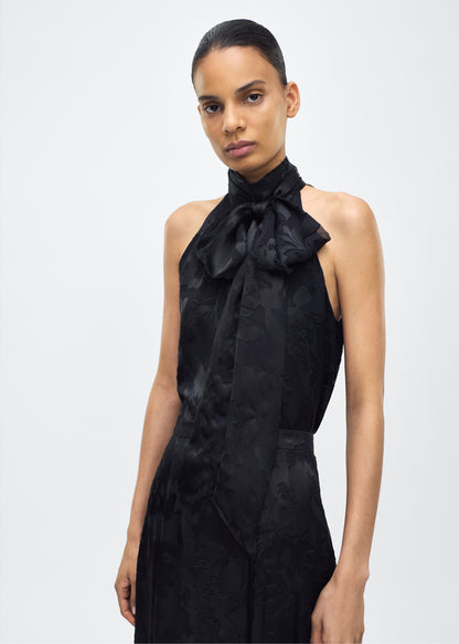 Image of model facing front – giulia top, P25117DV, Black – Adam Lippes, P25 collection: The Giulia Top is crafted from elegant burn-out fabric, and features an intricate floral design. The classic black hue enhances the rich texture, while the flowing silhouette exudes sophistication. Pair with the Emi Skirt in Devore for a coordinated ensemble.
