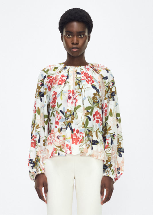 Model facing front – lottie top , P25130CC, ivory floral – Adam Lippes, P25 collection: The Lottie Top debuts in a new silhouette, featuring a classic ivory floral motif on refined crepe de chine. A delicately gathered neckline, airy sleeves, and soft hemline evoke a sense of lightness and fluidity.