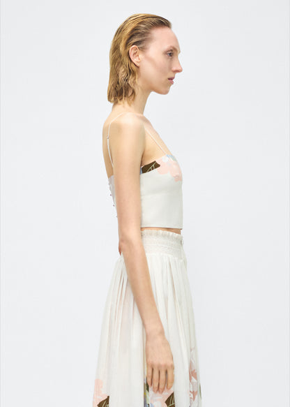 Image of model facing side – bex top, P25143PV, champagne/multi – Adam Lippes, P25 collection: Crafted from 100% cotton voile, the Bex Top showcases this season’s Sicily-inspired floral motif. The cropped silhouette offers a modern fit, while delicate straps and a clean neckline lend a minimalist touch. 
