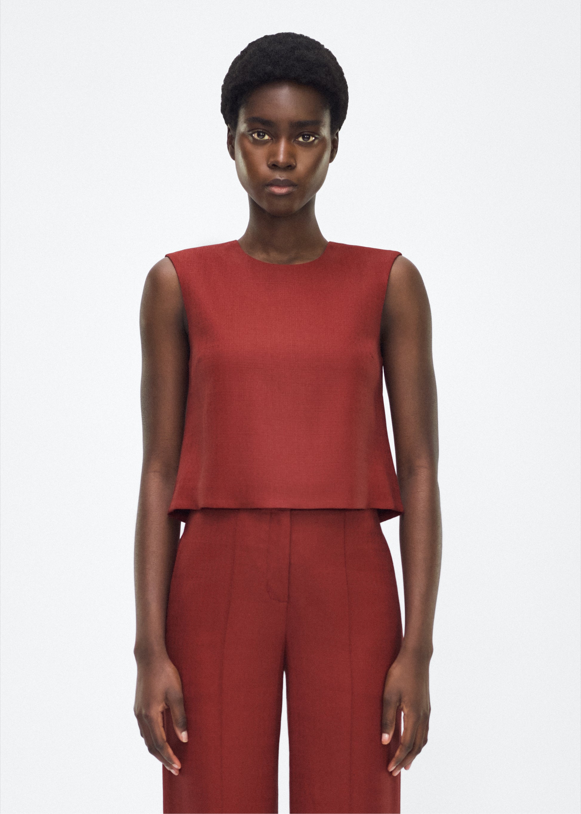 Image of model facing front– mercer top, P25144TR, sienna – Adam Lippes, P25 collection: This cropped-silhouette top is crafted from stretch canvas in a rich sienna hue, offering a perfect balance of softness and structure. A box pleat at the back adds subtle, refined shape.
