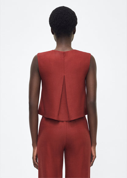 Image of model facing back  mercer top, P25144TR, sienna – Adam Lippes, P25 collection: This cropped-silhouette top is crafted from stretch canvas in a rich sienna hue, offering a perfect balance of softness and structure. A box pleat at the back adds subtle, refined shape.