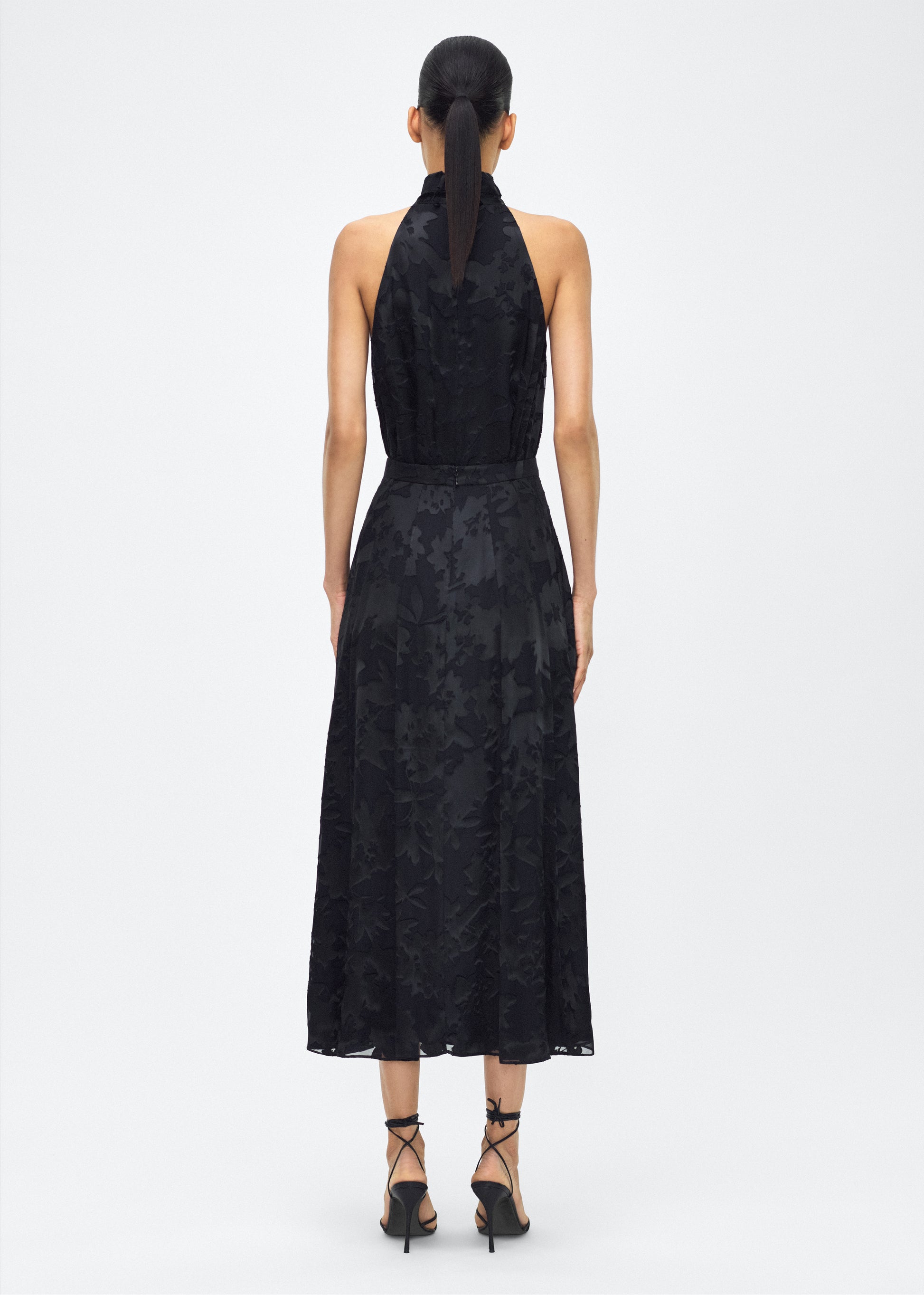 model image facing back – Emi Skirt, P25410DV, Black – Adam Lippes, P25 collection: The Emi Skirt is crafted from elegant burn-out fabric, and features an intricate floral design. The classic black hue, paired with the floral pattern, creates a striking yet sophisticated look. Pair with the Giulia Top for a coordinated ensemble.
