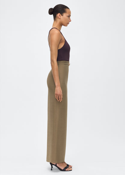 Model facing side– Leto Skirt, P25412SW, Military Green – Adam Lippes, P25 collection:The Leto Skirt offers an elevated pencil silhouette, crafted from luxurious silk wool in a sophisticated military green hue. The sleek design is accentuated by a fabric-covered belt, cinching the waist for a tailored fit.