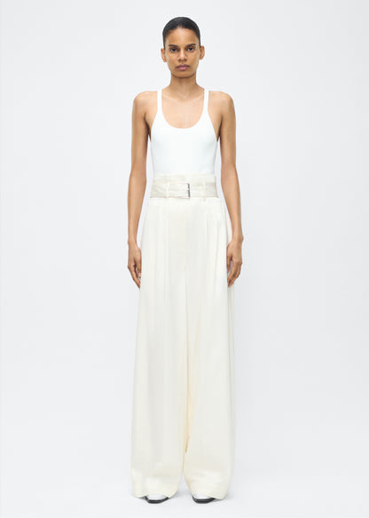 Image of model facing front – Jericho Pant, P25505WI, Ivory – Adam Lippes, P25 collection: The Jericho Pant is crafted from luxurious cotton-cashmere twill, offering the perfect balance of softness and structure. Pleated fronts and a wide-leg design create an easy, relaxed fit, while a belt at the waist adds elegant definition.