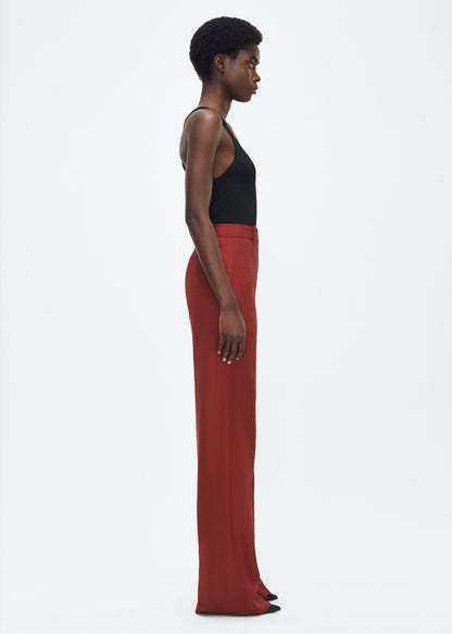 Image of model facing side – Wyatt Pant, P25507TR, Sienna – Adam Lippes, P25 collection: Precision tailoring meets modern ease in the Wyatt Pant, crafted in lightweight canvas and rendered in a rich sienna hue. The silhouette is clean and elongating, with a high-rise waist and fabric that moves effortlessly while holding its shape.