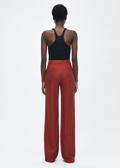 Image of model facing back – Wyatt Pant, P25507TR, Sienna – Adam Lippes, P25 collection: Precision tailoring meets modern ease in the Wyatt Pant, crafted in lightweight canvas and rendered in a rich sienna hue. The silhouette is clean and elongating, with a high-rise waist and fabric that moves effortlessly while holding its shape.