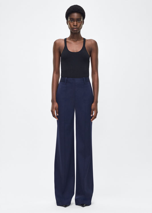 Image of model facing front– Wyatt Pant, P25507TW, Navy – Adam Lippes, P25 collection: Precision tailoring meets warm-weather ease in the Wyatt Pant, now rendered in lightweight tropical wool. Cut in a deep navy hue, the silhouette is sleek and elongating, with a high-rise waist and fluid shape ideal for refined summer dressing.