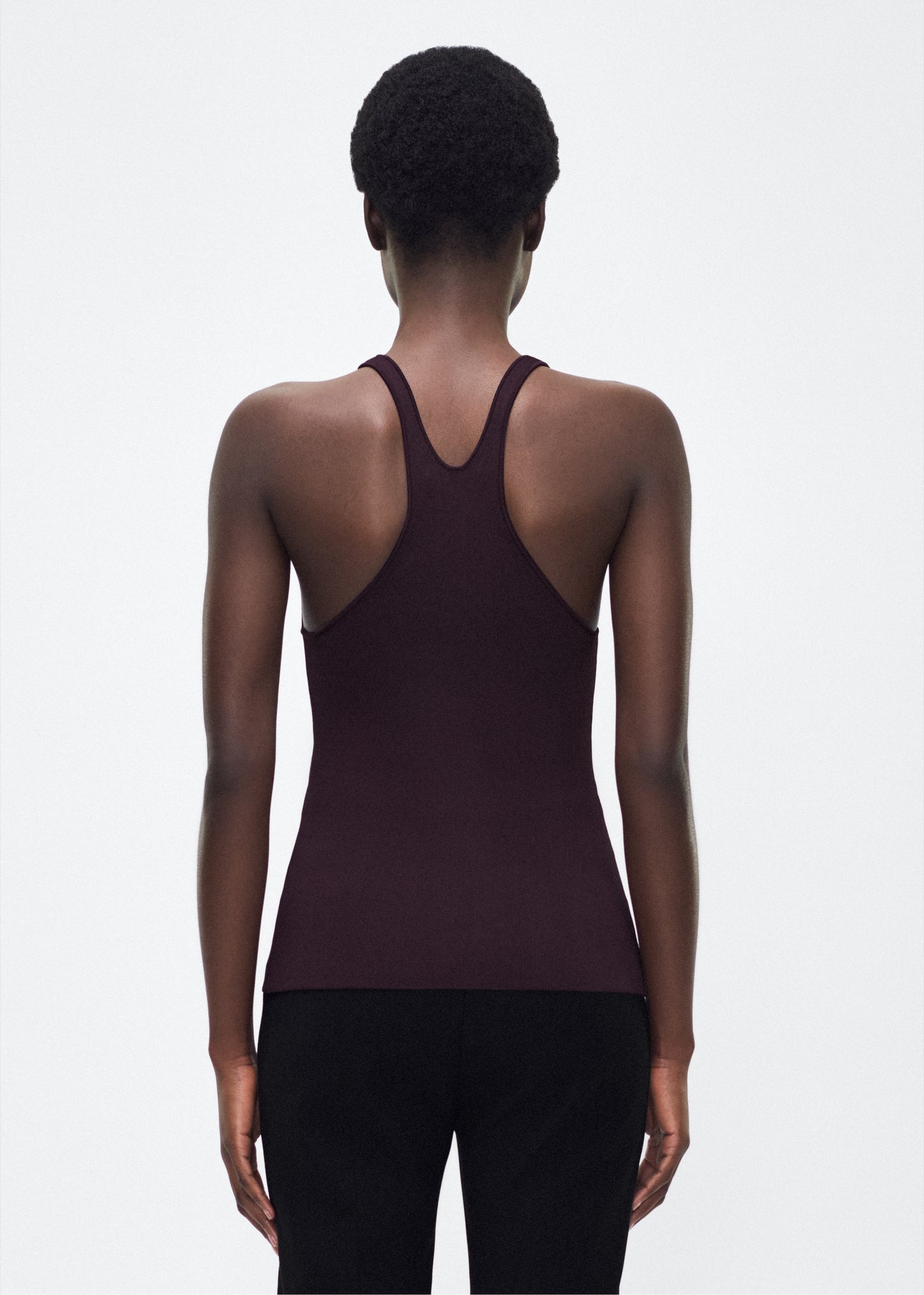 Image of model facing back – lumii tank , P25601VI, cacao – Adam Lippes, P25 collection: A new silhouette from the atelier, the Lumii Tank is crafted from luxurious knitted viscose. Clean lines and athletic-inspired straps make it a versatile piece for layering or wearing alone.
