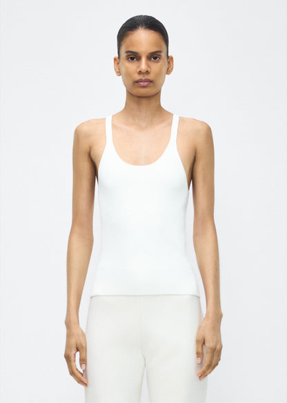 Image of model facing the front– lumii tank , P25601VI, ivory – Adam Lippes, P25 collection:A new silhouette from the atelier, the Lumii Tank is crafted from luxurious knitted viscose. Clean lines and athletic-inspired straps make it a versatile piece for layering or wearing alone.