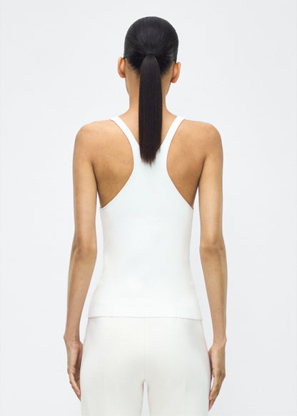 Image of model facing the back lumii tank , P25601VI, ivory – Adam Lippes, P25 collection:A new silhouette from the atelier, the Lumii Tank is crafted from luxurious knitted viscose. Clean lines and athletic-inspired straps make it a versatile piece for layering or wearing alone.