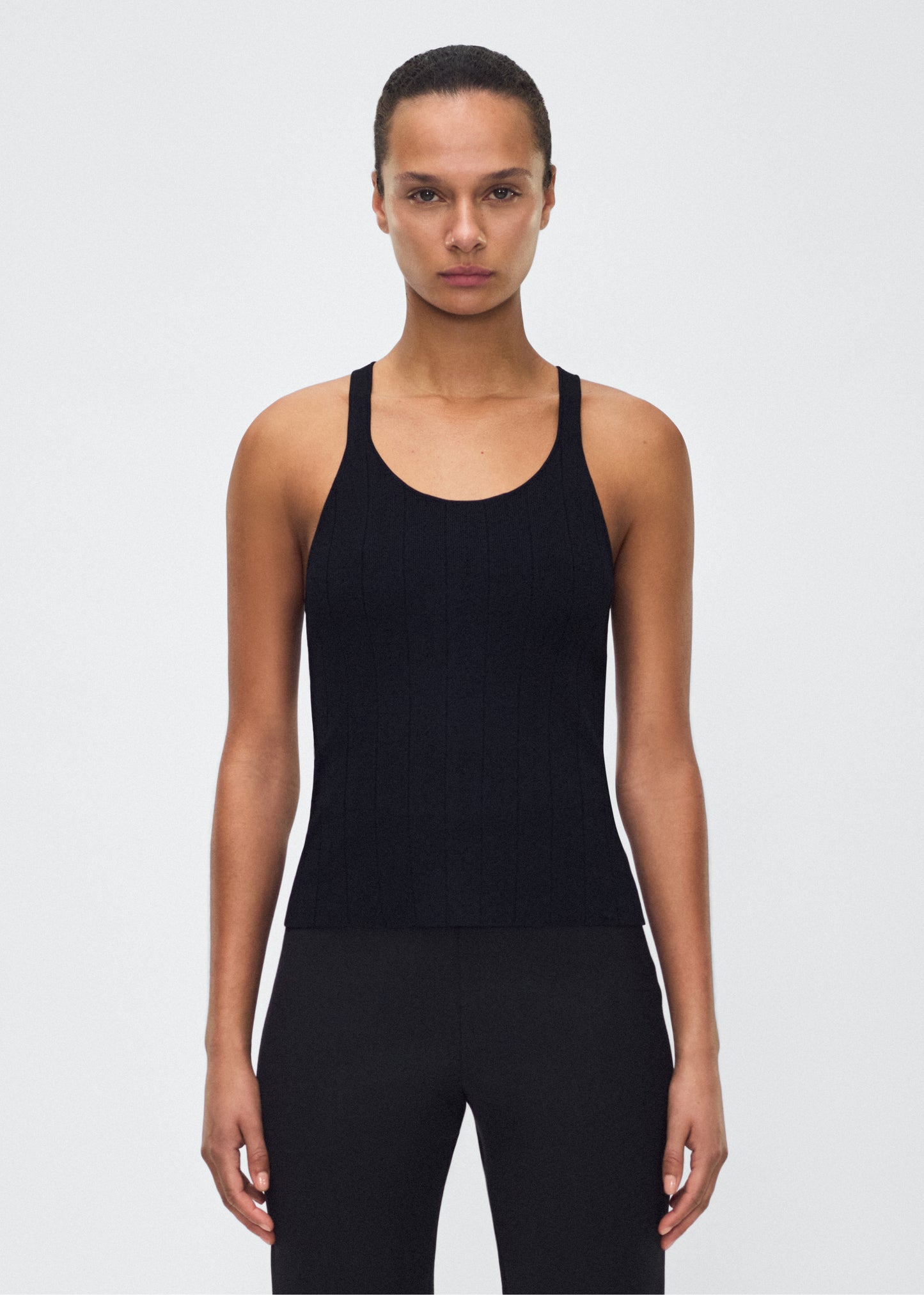 Image of model facing front– lumii tank , P25624UB, black – Adam Lippes, P25 collection: A new silhouette from the atelier, the Lumii Tank is crafted from structured compact jacquard. Clean lines and athletic-inspired straps make it a versatile piece for layering or wearing alone.
