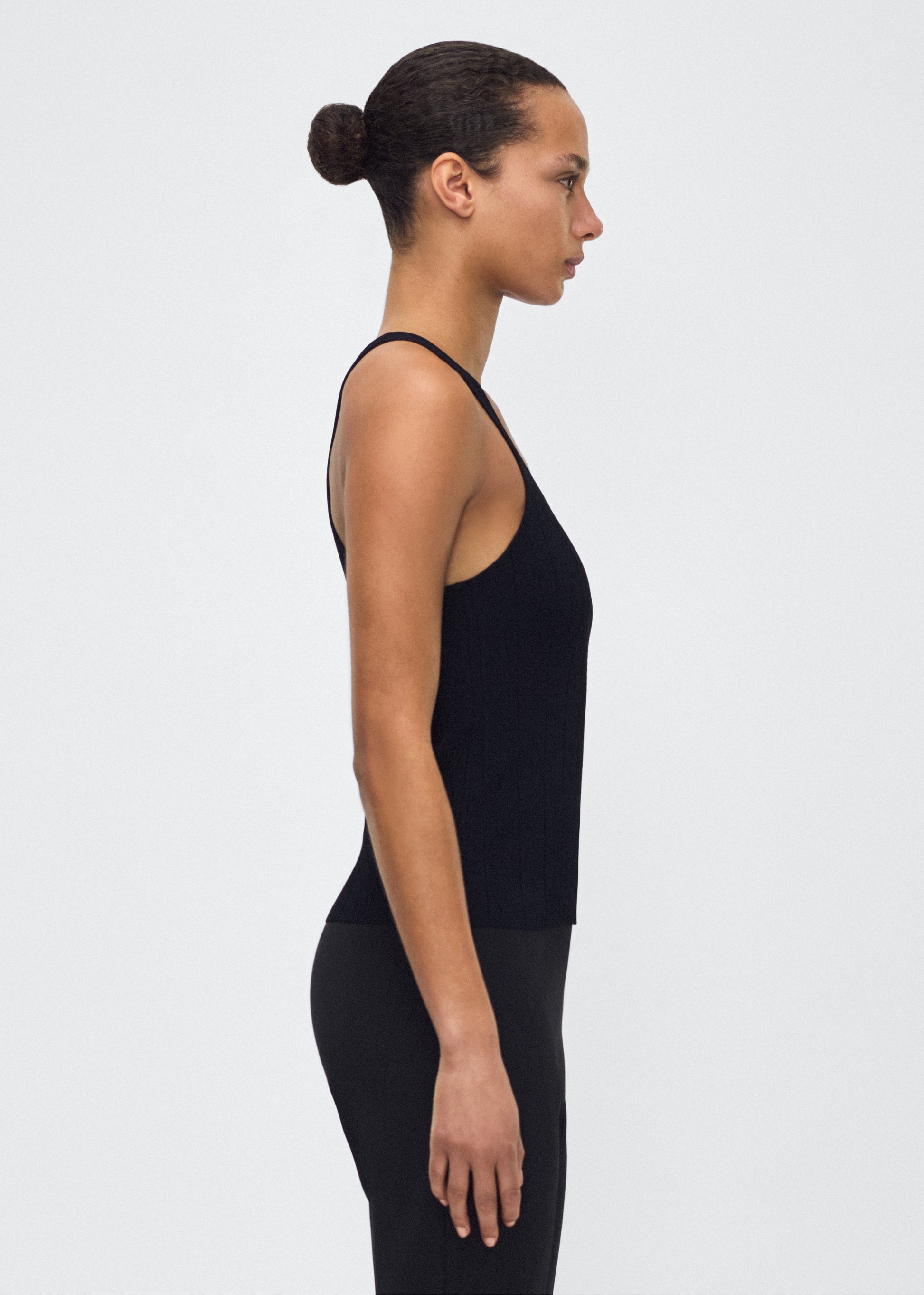 Image of model facing side lumii tank , P25624UB, black – Adam Lippes, P25 collection: A new silhouette from the atelier, the Lumii Tank is crafted from structured compact jacquard. Clean lines and athletic-inspired straps make it a versatile piece for layering or wearing alone.