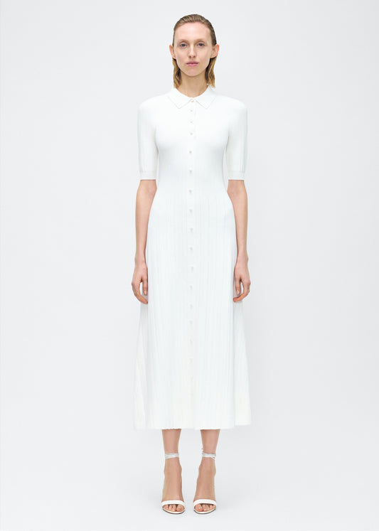 Model facing front – Fenwick Dress, P25626UB, Ivory – Adam Lippes, P25 collection: Crafted from a supple, ribbed knit, this dress skims th figure with ease, while an inset panel through the skirt introduces fluid movement. A button-down front and structured collar complete the look.