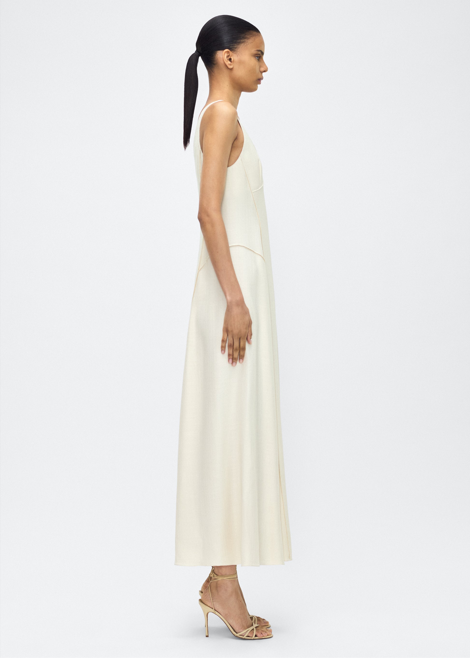 Model facing side, P25718TR, Shay Dress in Ivory, Crafted from versatile stretch canvas, the Shay dress features a structured silhouette with a softly contoured waistline and fluid, voluminous skirt. A scoop neckline and tailored side seams create an elongating effect.