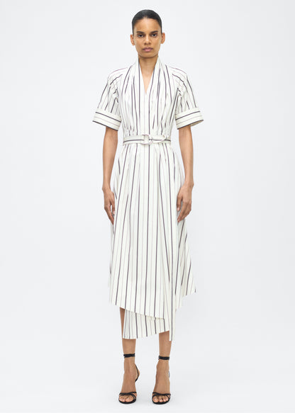 Model facing front, P25723SS, Ivory/Black, P25 Adam Lippes collection: The Nansi Dress is crafted from crisp stripe poplin in ivory and black, featuring an asymmetrical hem that adds a modern twist to a classic design. A sleek V-neckline and short sleeves enhance its effortless sophistication, while a fabric belt cinches the waist for a defined silhouette.
