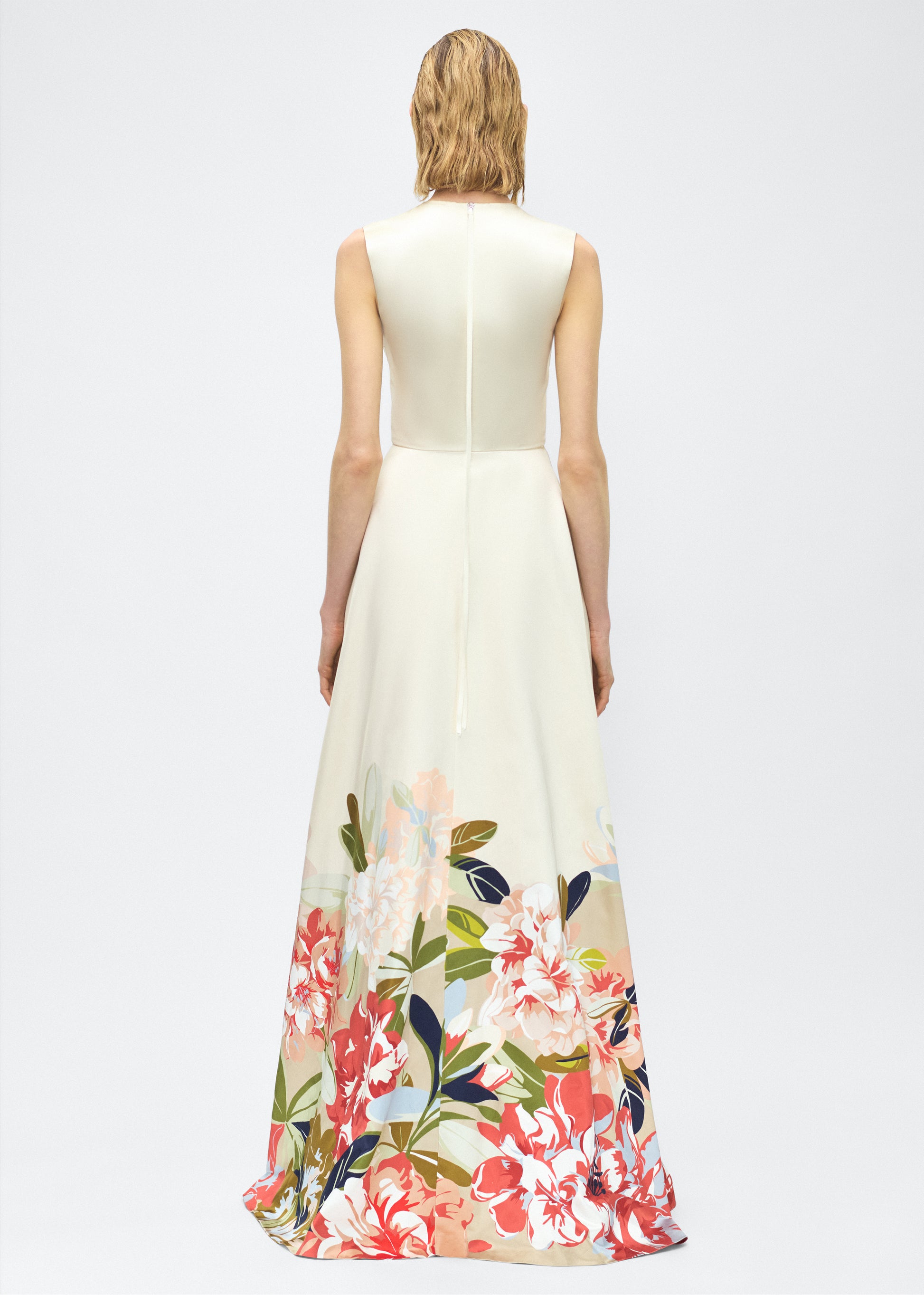 Image of model facing back – Alienor Dress, P25731PU, Champagne/Multi – Adam Lippes, P25 collection: The Alienor Dress in printed duchess satin is defined by its elegant simplicity. Adorned with the Pre-Fall collection’s Sicily-inspired floral motif, it features a classic rounded neckline and flows gracefully for effortless wear.