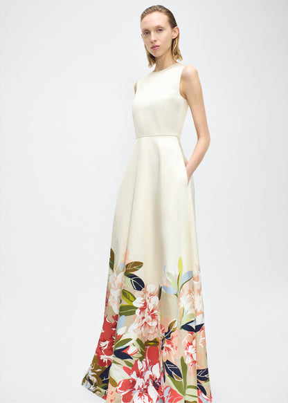 Image of model facing forward angled – Alienor Dress, P25731PU, Champagne/Multi – Adam Lippes, P25 collection: The Alienor Dress in printed duchess satin is defined by its elegant simplicity. Adorned with the Pre-Fall collection’s Sicily-inspired floral motif, it features a classic rounded neckline and flows gracefully for effortless wear.