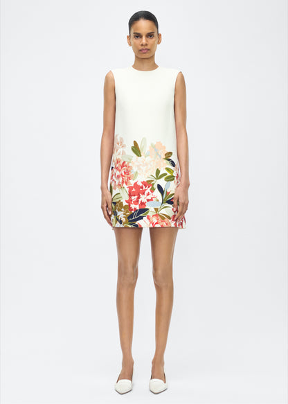 image of model facing front – ani dress, P25750PW, ivory multi – Adam Lippes, P25 collection: Rendered in luxurious silk wool, the Ani Dress features this season’s Sicily-inspired floral motif. The dress is designed with a clean, sleeveless silhouette, offering a sharp A-line shape that gracefully skims the body. 