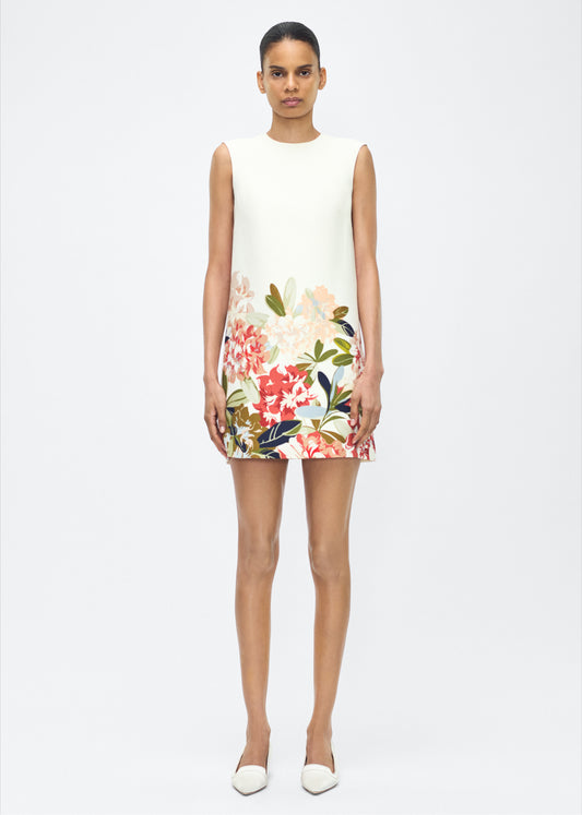 image of model facing front – ani dress, P25750PW, ivory multi – Adam Lippes, P25 collection: Rendered in luxurious silk wool, the Ani Dress features this season’s Sicily-inspired floral motif. The dress is designed with a clean, sleeveless silhouette, offering a sharp A-line shape that gracefully skims the body. 