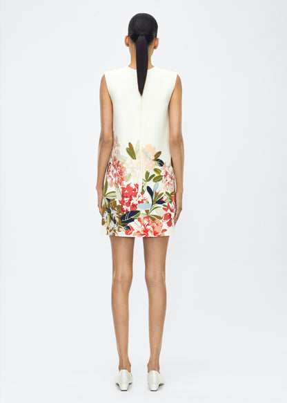 image of model facing back – ani dress, P25750PW, ivory multi – Adam Lippes, P25 collection: Rendered in luxurious silk wool, the Ani Dress features this season’s Sicily-inspired floral motif. The dress is designed with a clean, sleeveless silhouette, offering a sharp A-line shape that gracefully skims the body. 