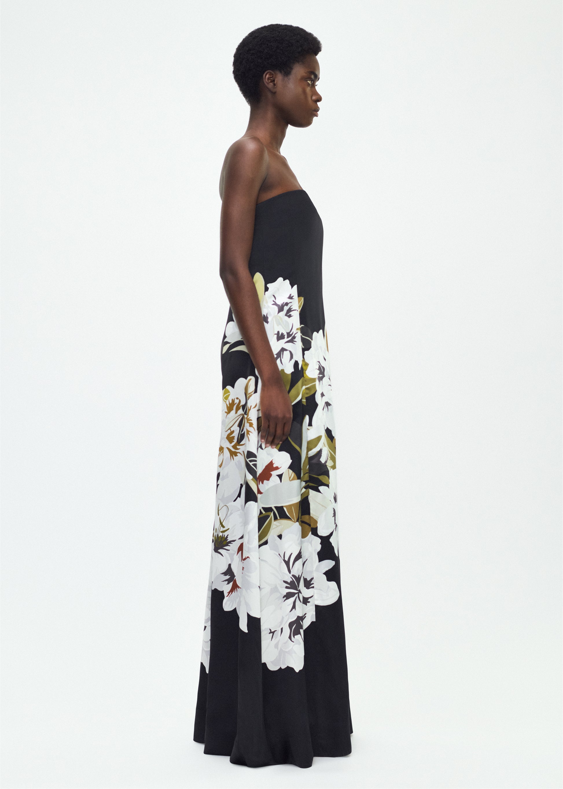 Model facing side, P25761PD, the Marais Dress in Black/white, Adam Lippes P25 Collection, The strapless silhouette of the Marais Dress offers an elegant, flowing shape for formal occasions. Luminous silk is beautifully adorned with this season’s Sicily-inspired floral motif.