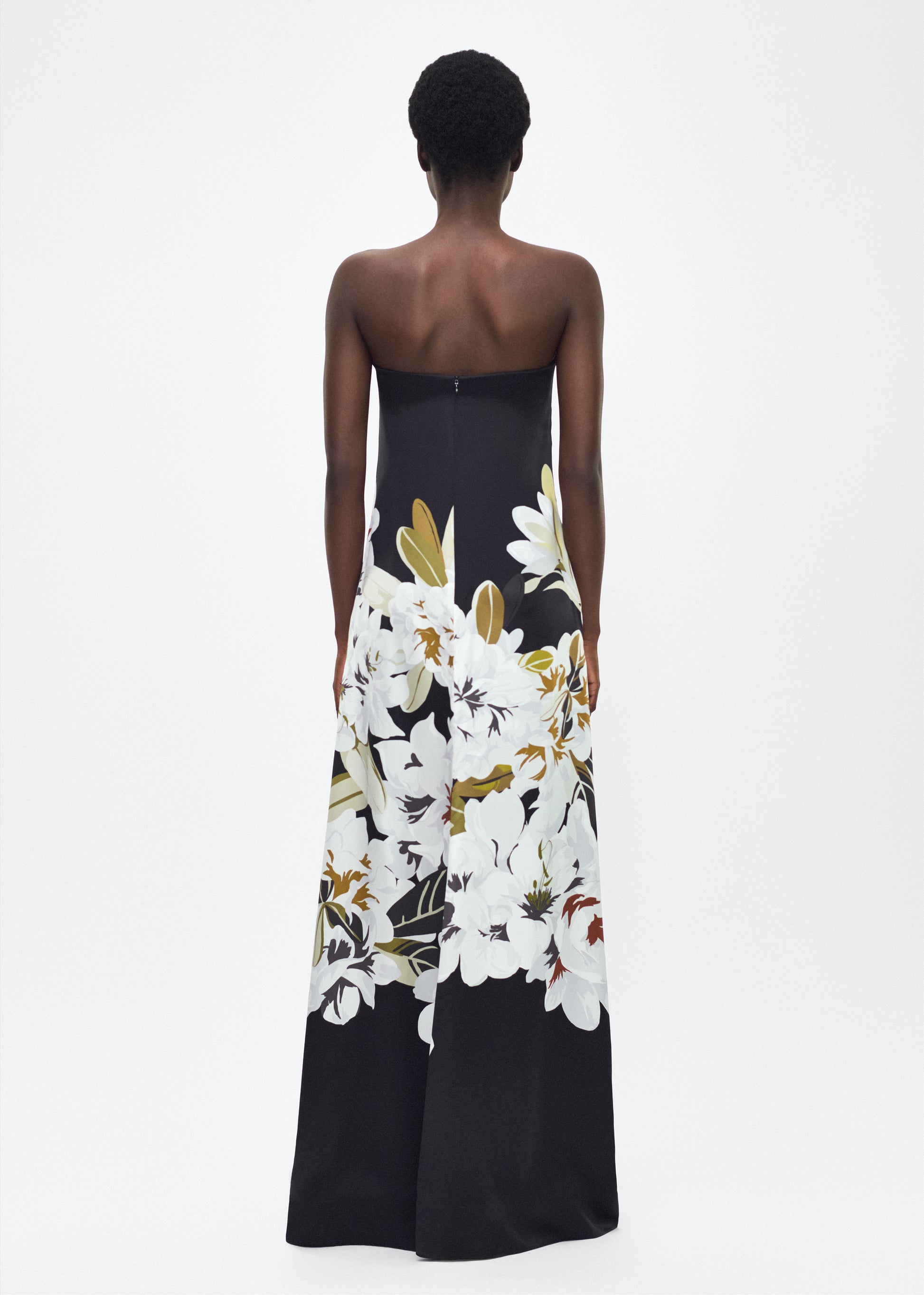 Model facing back, P25761PD, the Marais Dress in Black/white, Adam Lippes P25 Collection, The strapless silhouette of the Marais Dress offers an elegant, flowing shape for formal occasions. Luminous silk is beautifully adorned with this season’s Sicily-inspired floral motif.