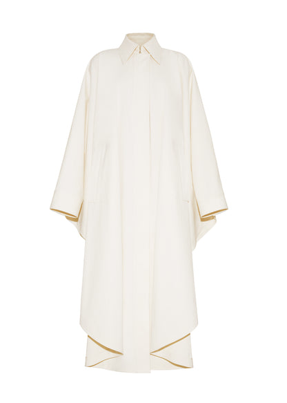 Ghost image front, The Langston Poncho, P25914CT, in color ivory, Adam Lippes P25 collection; The Langston Poncho in ivory cotton twill offers an elegant take on the classic poncho. With its modern, relaxed shape, sharp tailoring, and hidden corozo button closure down the center front, it effortlessly elevates any ensemble. The ivory hue and clean lines are complemented by thoughtful details.