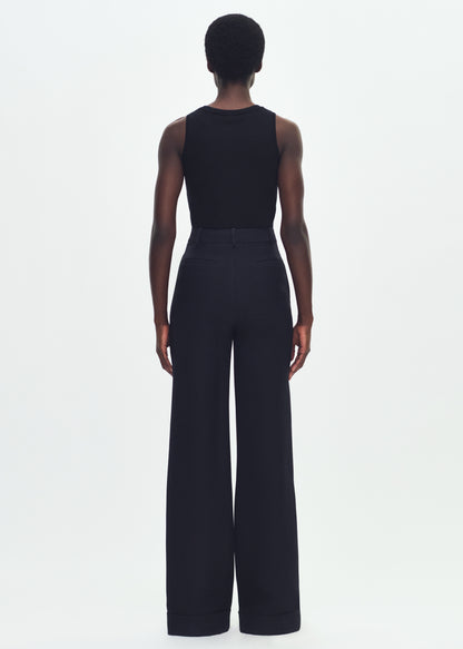 Image of a model facing backward wearing a black sleeveless top tucked into black wide leg pants.