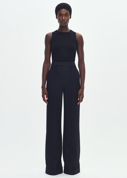 Image of a model facing forward wearing a black sleeveless top tucked into black wide leg pants.