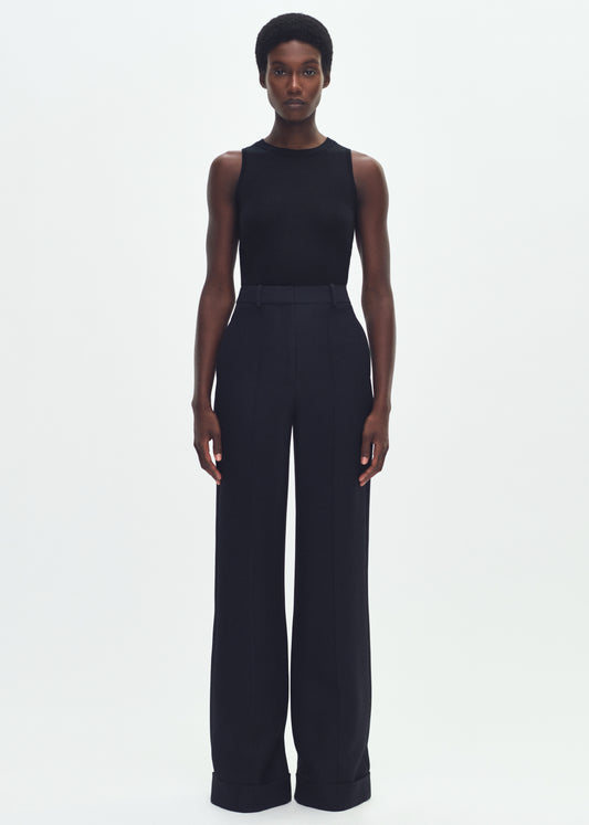 Image of a model facing forward wearing a black sleeveless top tucked into black wide leg pants.
