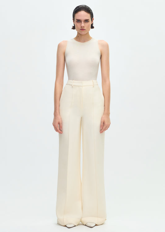 Image of a model facing forward wearing an ivory sleeveless tank tucked into ivory wide leg pants.