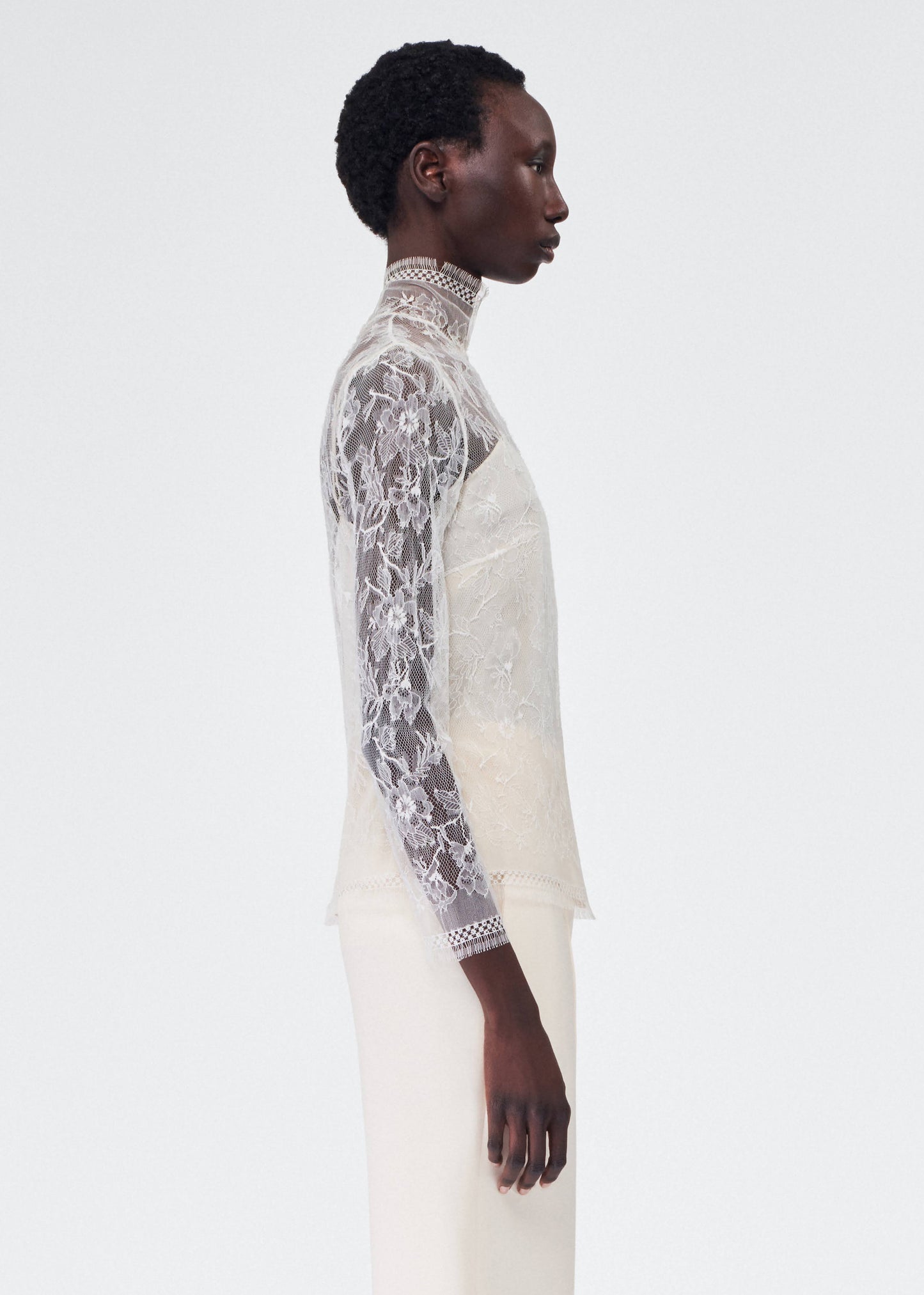 side view of model wearing the adam lippes chantilly lace turtleneck
